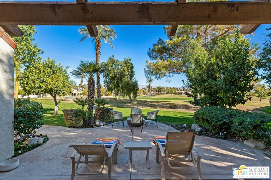 10201 Lakeview Drive Rancho Mirage, CA 92270 - Photo 22 of 28 a view of a swimming pool with lawn chairs potted plants and large tree