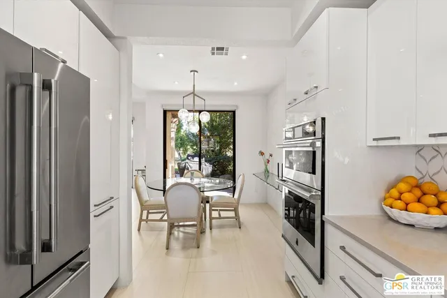 a view of a dining room with furniture a kitchen and chandelier