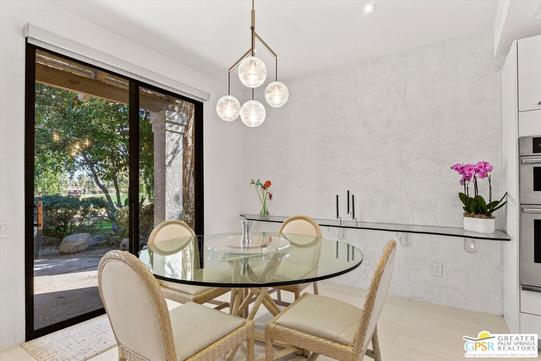 10201 Lakeview Drive Rancho Mirage, CA 92270 - Photo 24 of 28 a view of a dining room with furniture a potted plant and a floor to ceiling window