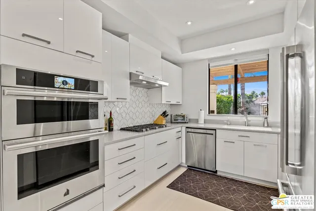 a kitchen with stainless steel appliances a stove sink and microwave