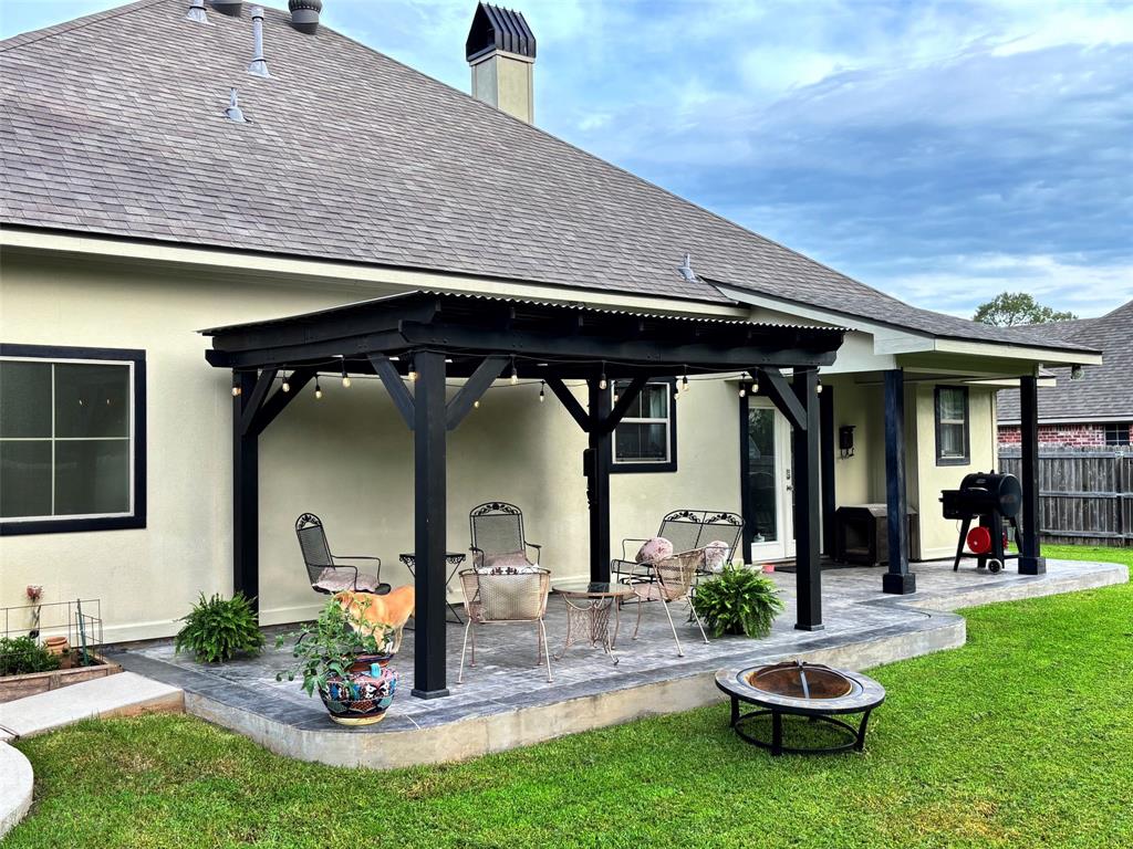 605 Jade Haughton, LA 71037 - Photo 28 of 34 Expansive backyard featuring a covered pergola with string lighting, a second covered porch ,a raised garden bed, and a fire pit