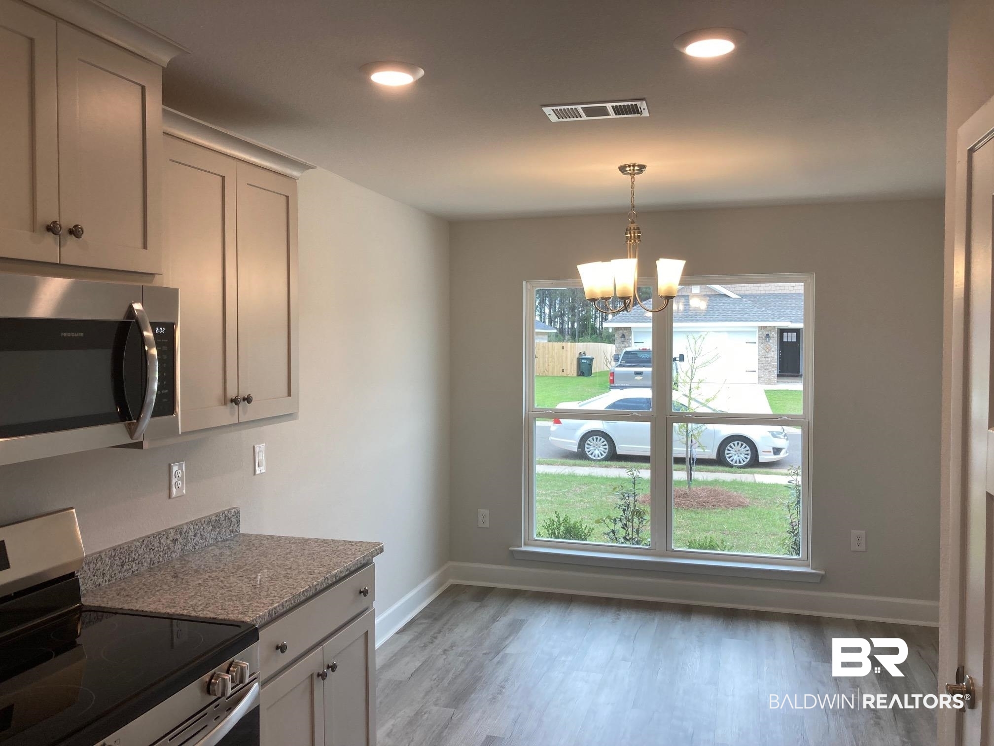 649 Revere Street Foley, AL 36535 - Photo 4 of 18 Kitchen featuring stainless steel appliances, baseboards, light wood-style floors, visible vents, and a notable chandelier