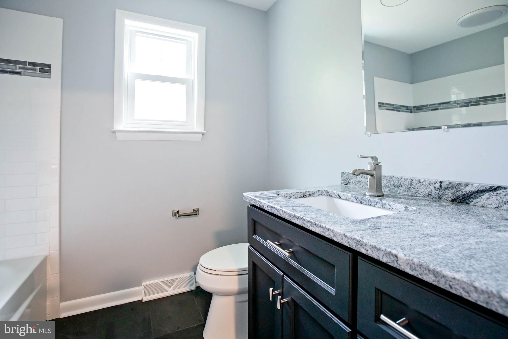 145 Forrest Avenue Runnemede, NJ 08078 - Photo 14 of 40 a bathroom with a granite countertop sink a toilet and a window