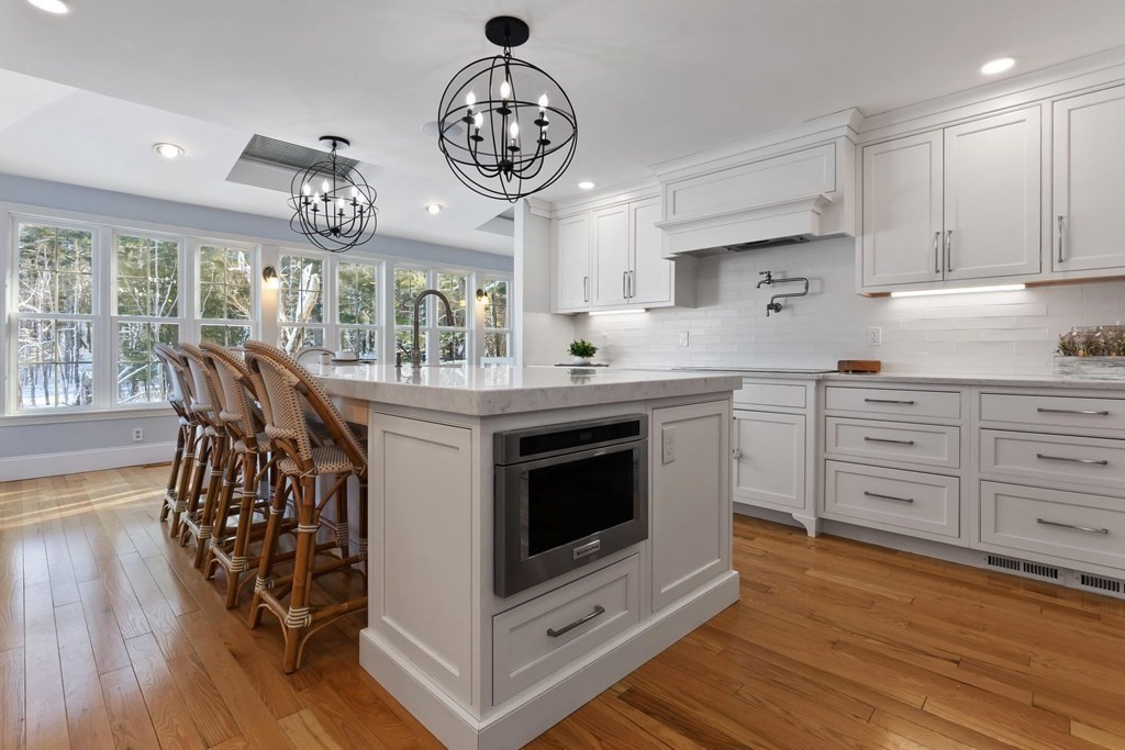 64 Jenkins Road Andover, MA 01810 - Photo 5 of 31 a kitchen with stainless steel appliances a stove a chandelier and wooden floors