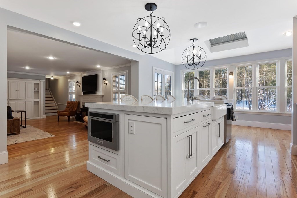 64 Jenkins Road Andover, MA 01810 - Photo 6 of 31 a kitchen with stainless steel appliances granite countertop a stove top oven a sink dishwasher a dining table and chairs with wooden floor
