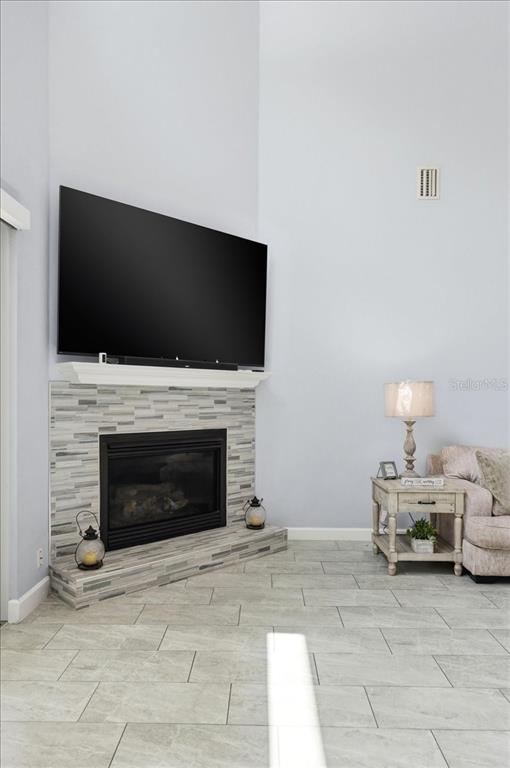 3943 West Campbell Road Lakeland, FL 33810 - Photo 32 of 95 a living room with furniture a fireplace and a flat screen tv