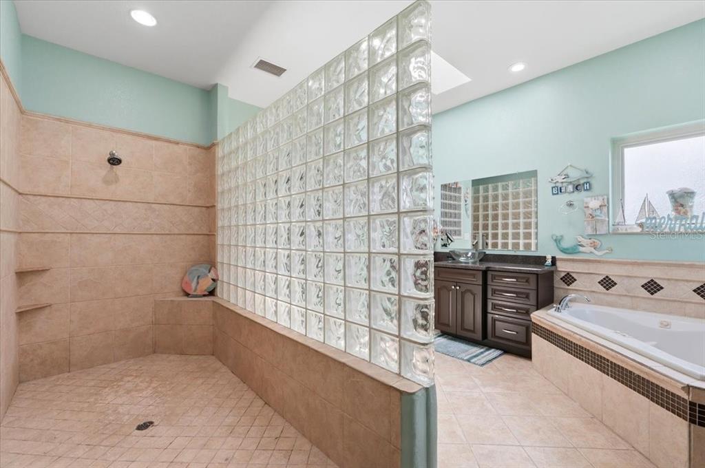 3943 West Campbell Road Lakeland, FL 33810 - Photo 53 of 95 a bathroom with a tub sink vanity granite and shower