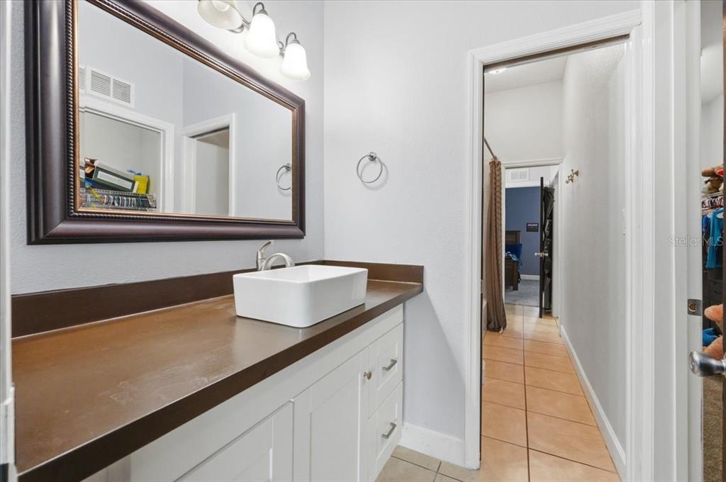 3943 West Campbell Road Lakeland, FL 33810 - Photo 71 of 95 a en suite bathroom with a granite countertop sink and a mirror