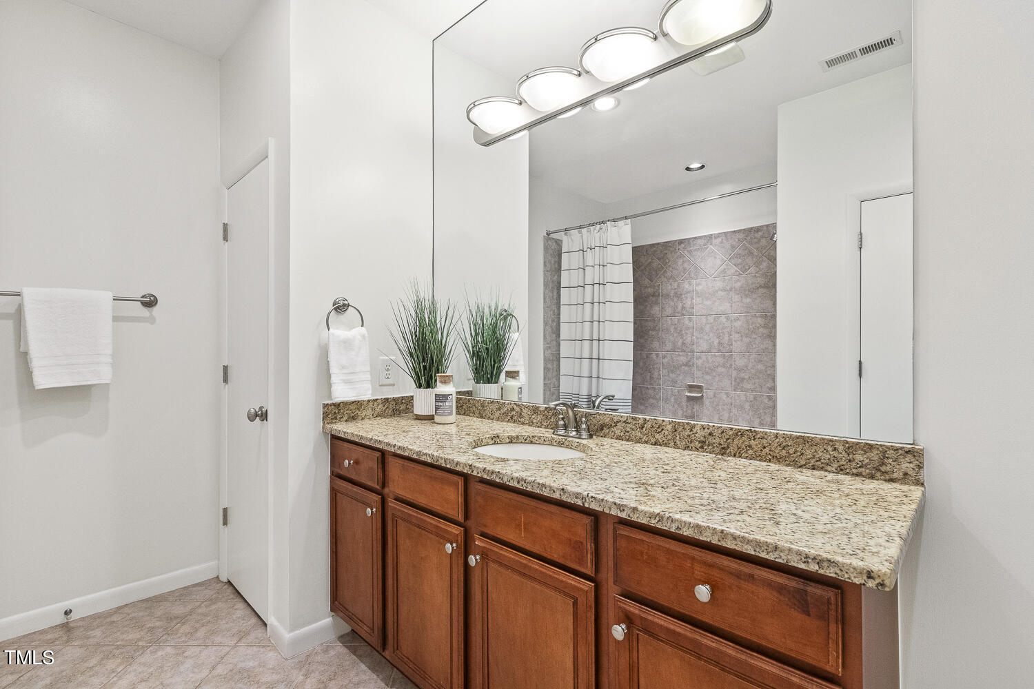 805 The Village Circle Raleigh, NC 27615 - Photo 32 of 42 a bathroom with a granite countertop sink and a mirror