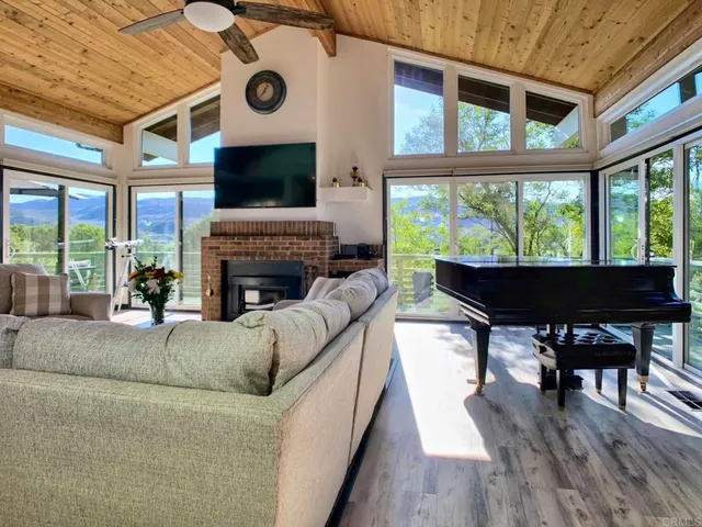 a living room with furniture a fireplace and a floor to ceiling window