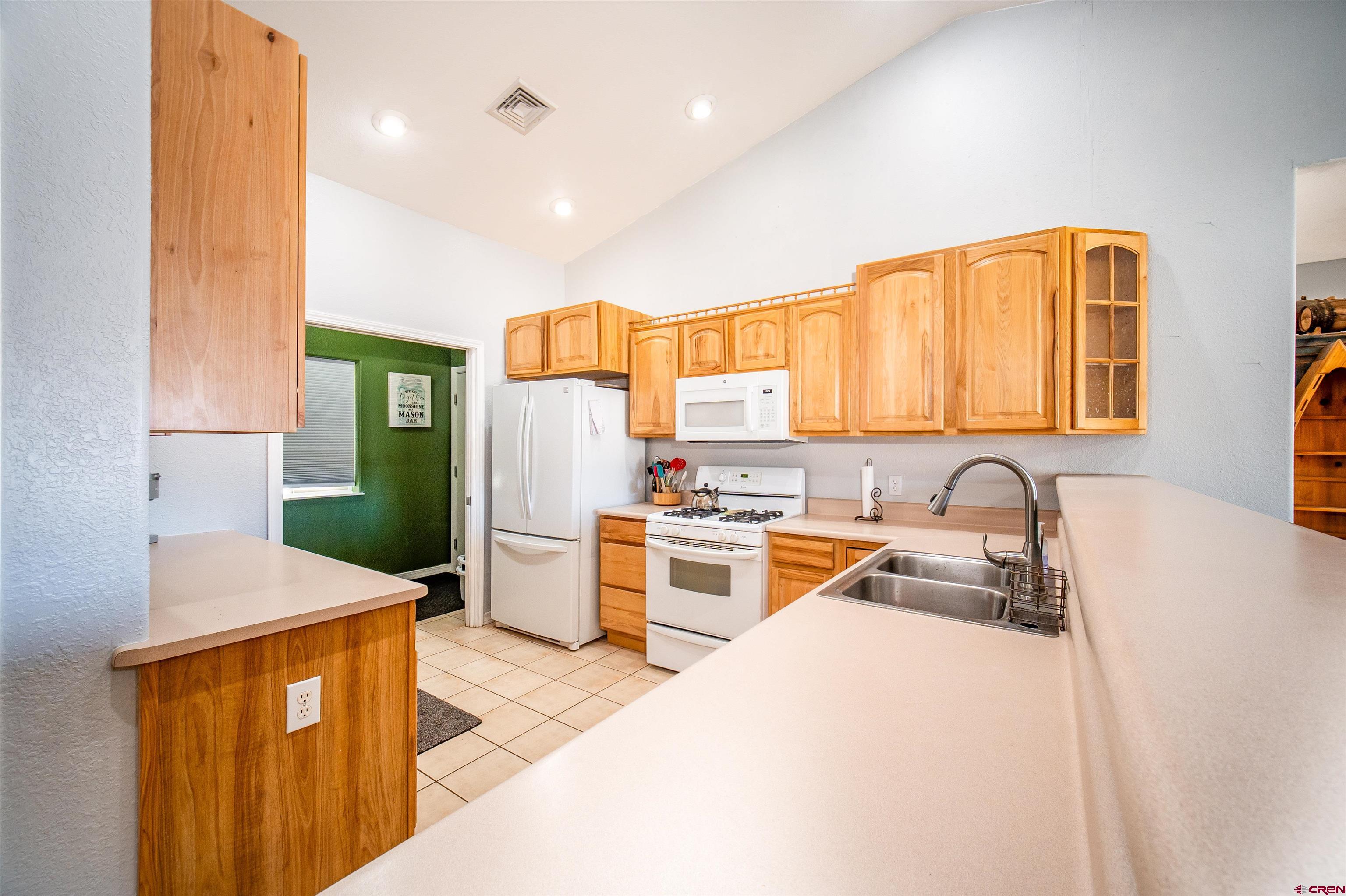 111 Meadowbrook Drive Bayfield, CO 81122 - Photo 9 of 30 a kitchen with a refrigerator a stove top oven and a sink