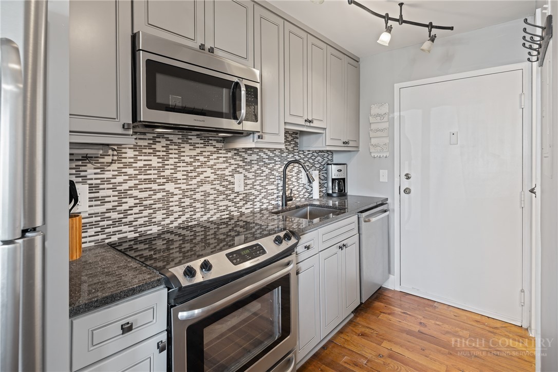 301 Pinnacle Inn Road, Unit 4103 Beech Mountain, NC 28604 - Photo 11 of 43 a kitchen with granite countertop cabinets stainless steel appliances and wooden floor