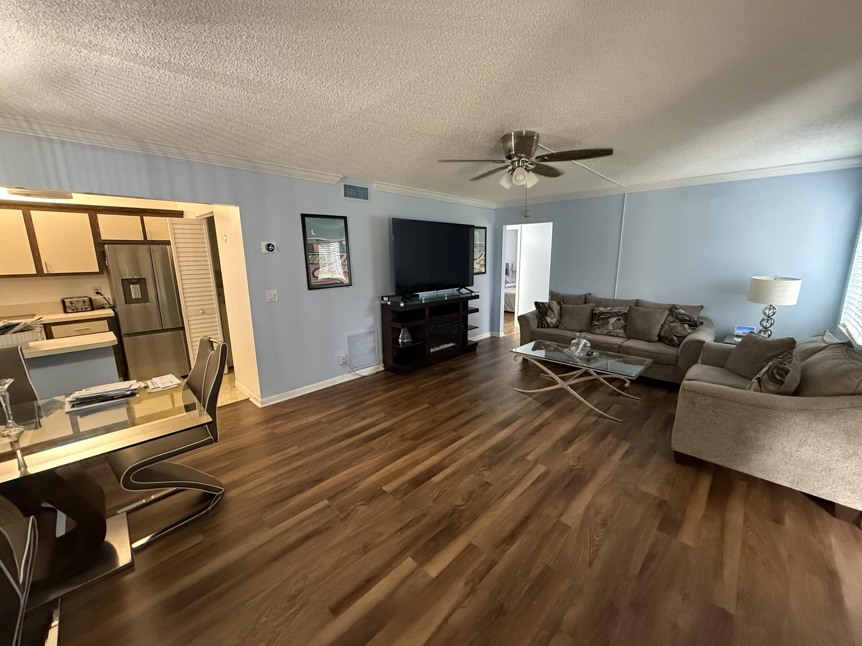 301 Pine Ridge Circle, Unit B1 Greenacres, FL 33463 - Photo 4 of 12 a living room with furniture gym equipment and a flat screen tv
