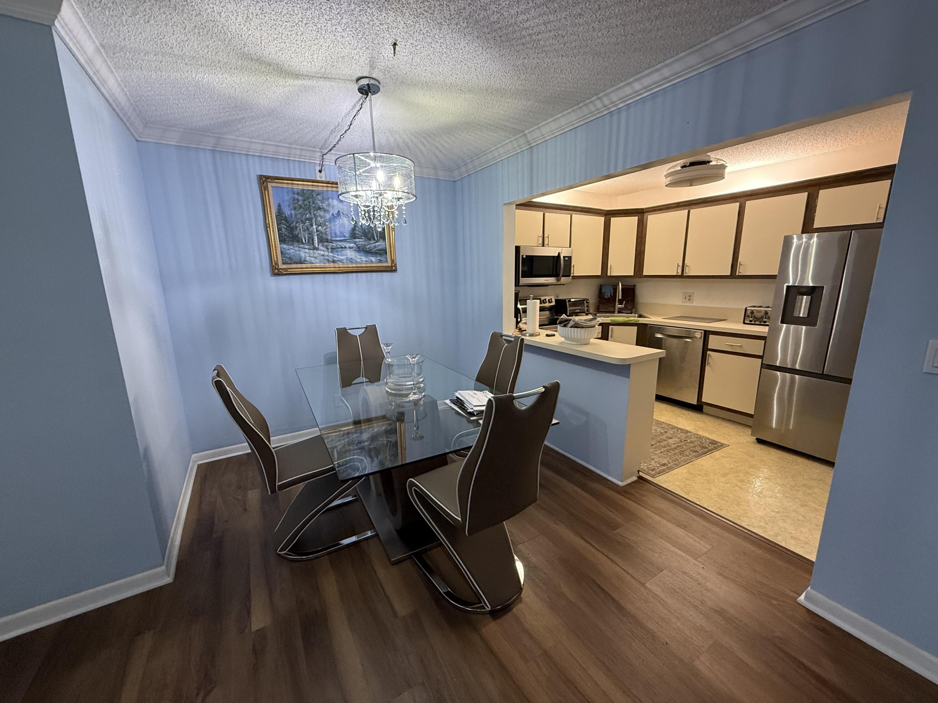 301 Pine Ridge Circle, Unit B1 Greenacres, FL 33463 - Photo 5 of 12 a view of a dining room with furniture window and wooden floor