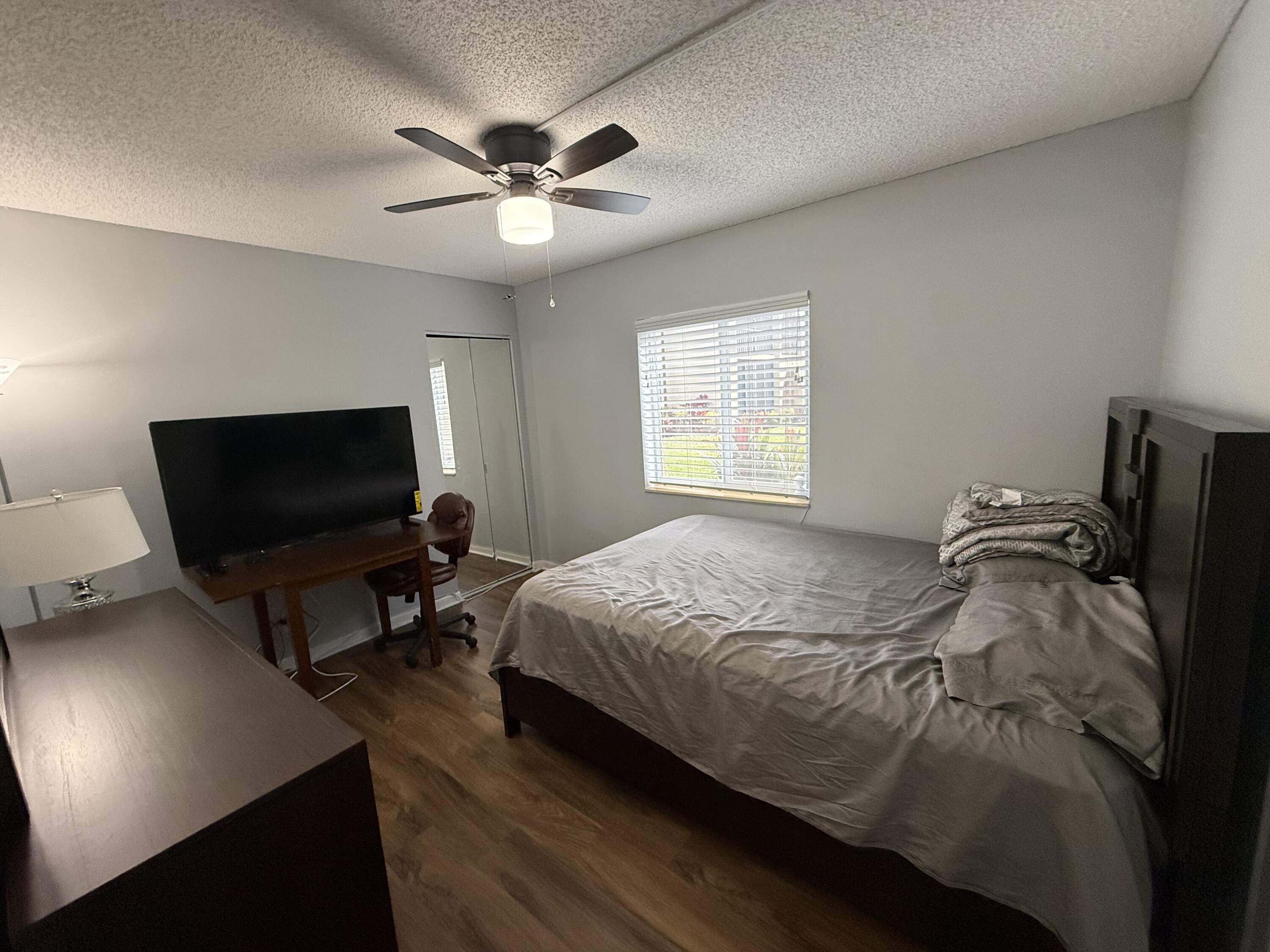 301 Pine Ridge Circle, Unit B1 Greenacres, FL 33463 - Photo 8 of 12 a bedroom with a bed and a flat screen tv