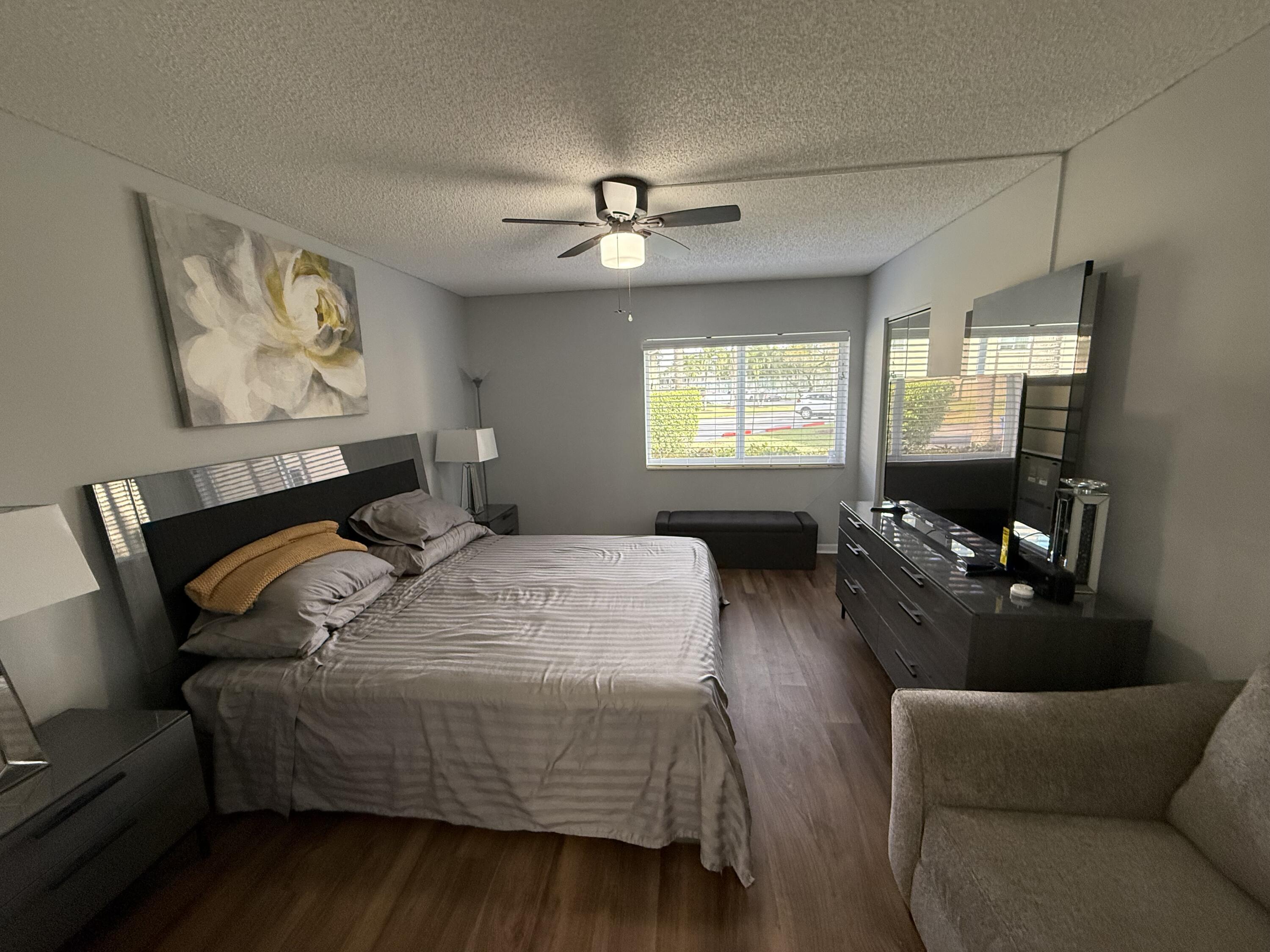 301 Pine Ridge Circle, Unit B1 Greenacres, FL 33463 - Photo 9 of 12 a bedroom with bed and wooden floor