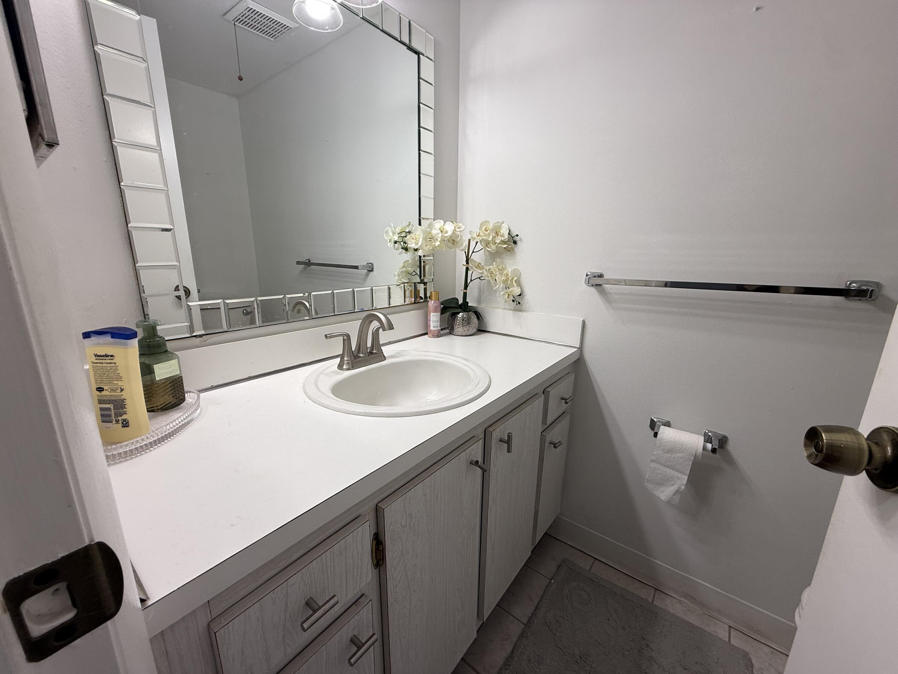 301 Pine Ridge Circle, Unit B1 Greenacres, FL 33463 - Photo 10 of 12 a bathroom with a sink and a mirror