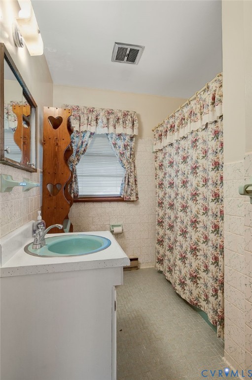6450 Holborn Road Richmond, VA 23224 - Photo 14 of 20 Full bathroom featuring vanity, tile walls, a show