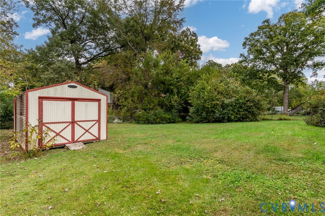 6450 Holborn Road Richmond, VA 23224 - Photo 20 of 20 View of grassy yard featuring a storage shed and v