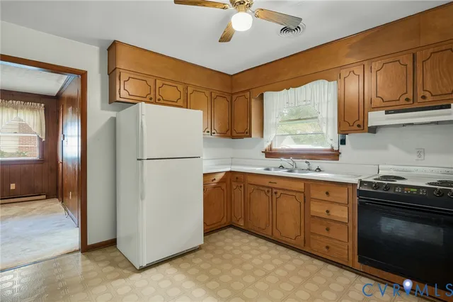 a kitchen with stainless steel appliances granite countertop a refrigerator a sink dishwasher a stove top oven a refrigerator and cabinets