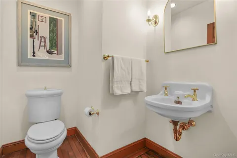 a bathroom with a sink toilet and a mirror