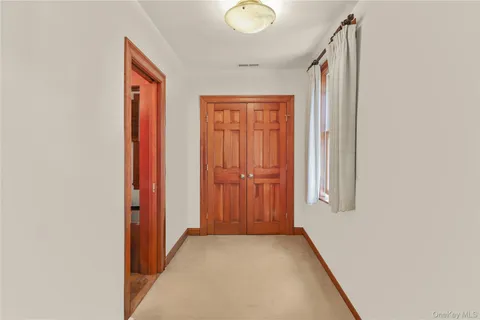 a view of a hallway with wooden floor and windows