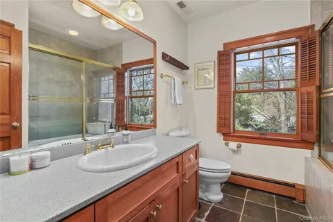 a bathroom with a sink a toilet and a large mirror
