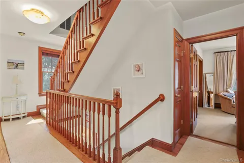 a view of staircase with lots of frames on wall and a window