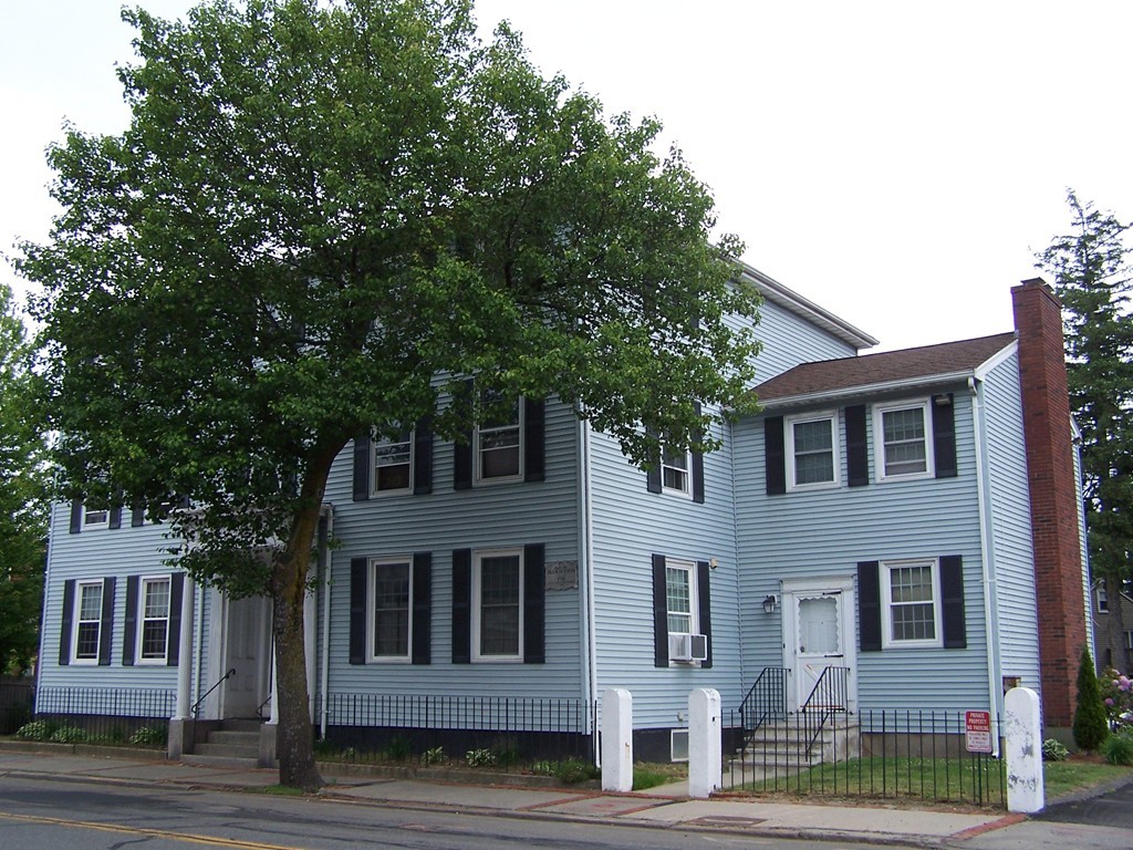 75 Cabot Street, Unit 13 Beverly, MA 01915 - Photo 2 of 13 a front view of a house with a garden