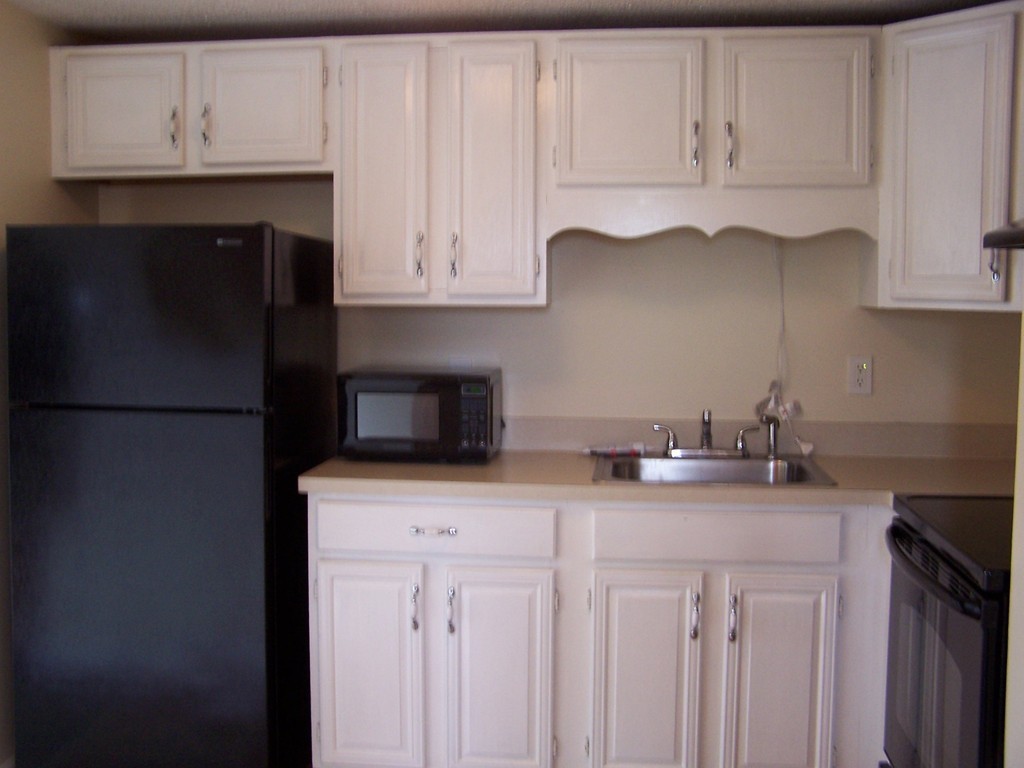 75 Cabot Street, Unit 13 Beverly, MA 01915 - Photo 4 of 13 a kitchen with white cabinets and refrigerator