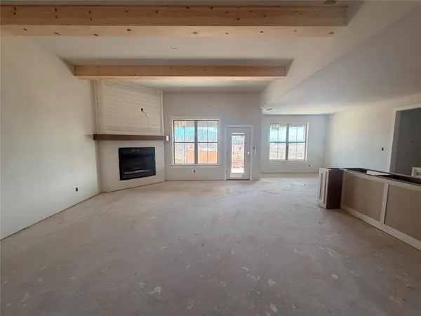 a view of an empty room with a fireplace and a window