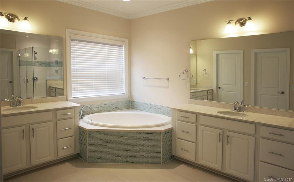 980 Emory Lane, Unit 112 Fort Mill, SC 29708 - Photo 17 of 23 a bath room with a sink double vanity granite tub shower and a mirror