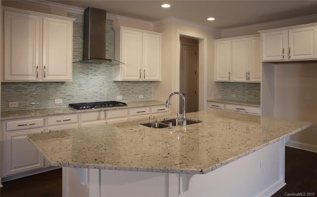 980 Emory Lane, Unit 112 Fort Mill, SC 29708 - Photo 4 of 23 a kitchen with granite countertop a sink a stove and a wooden cabinets