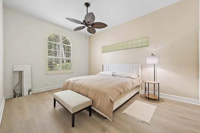 a bedroom with a bed chandelier and a window
