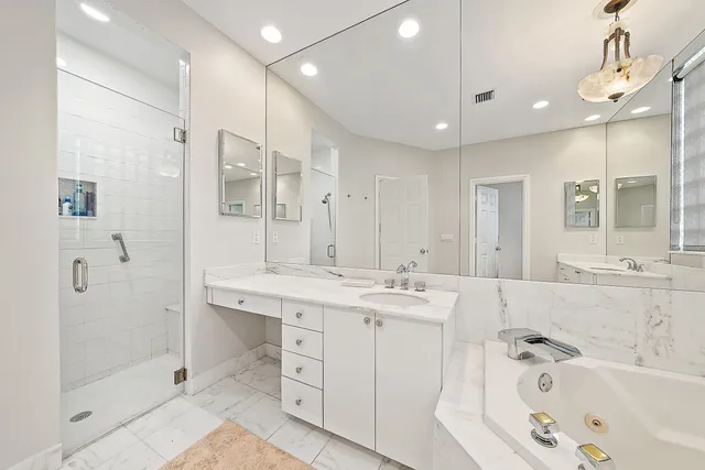a bathroom with a tub a sink shower and mirror