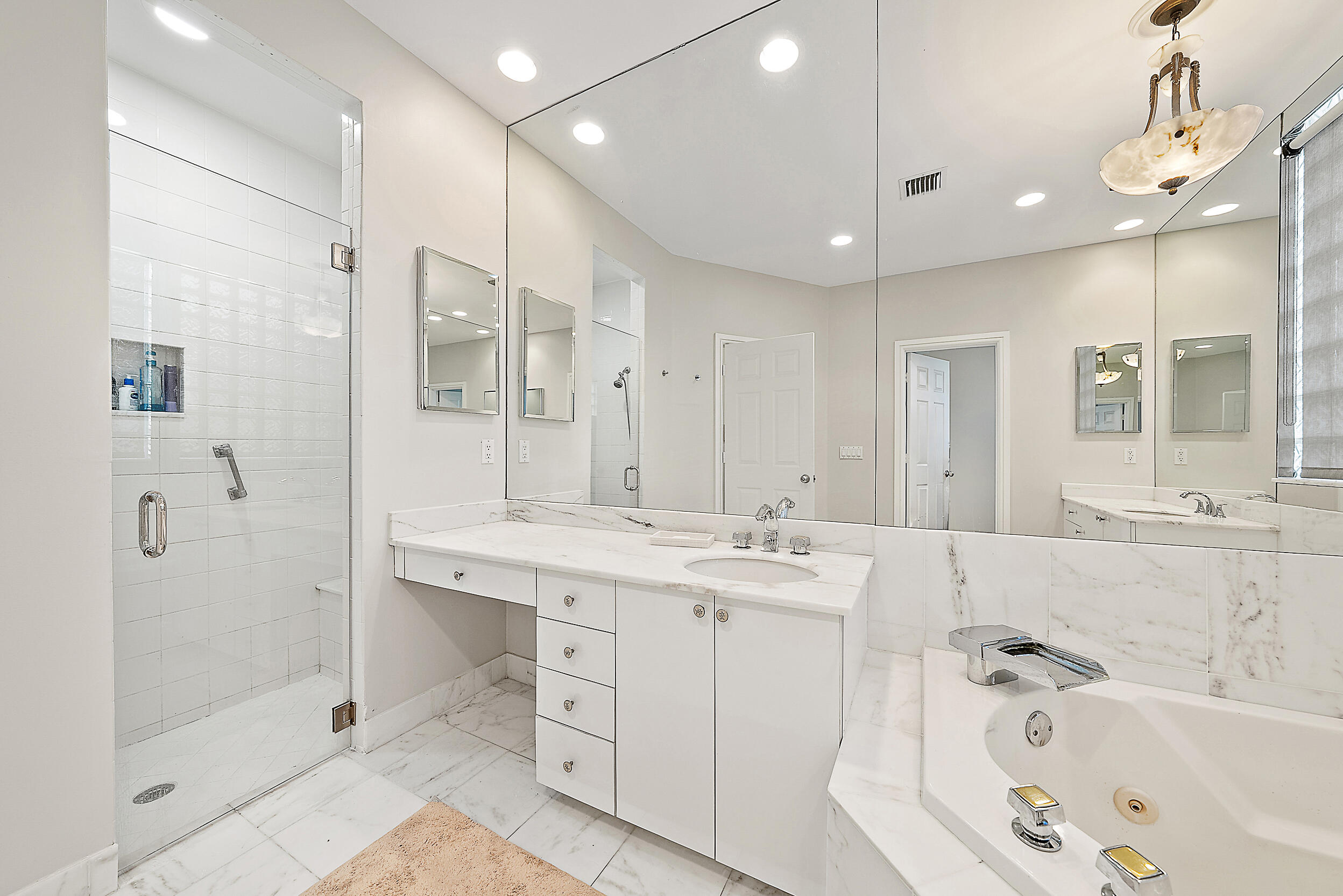 167 North Village Way Jupiter, FL 33458 - Photo 22 of 30 a bathroom with a tub a sink shower and mirror