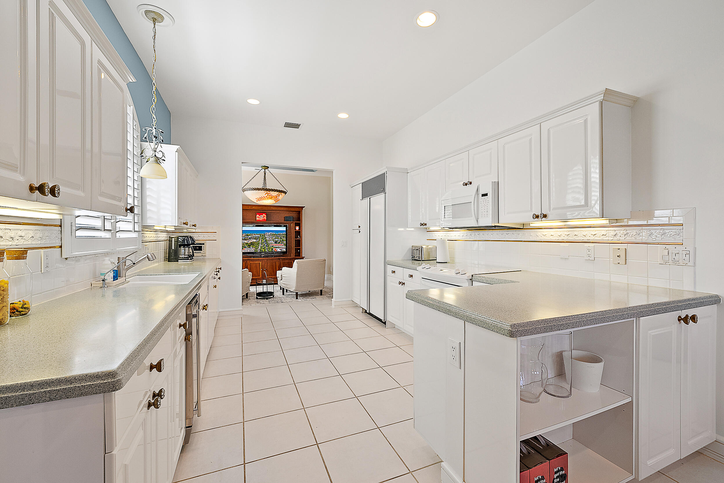 167 North Village Way Jupiter, FL 33458 - Photo 25 of 30 a kitchen with stainless steel appliances a sink a stove a refrigerator and cabinets