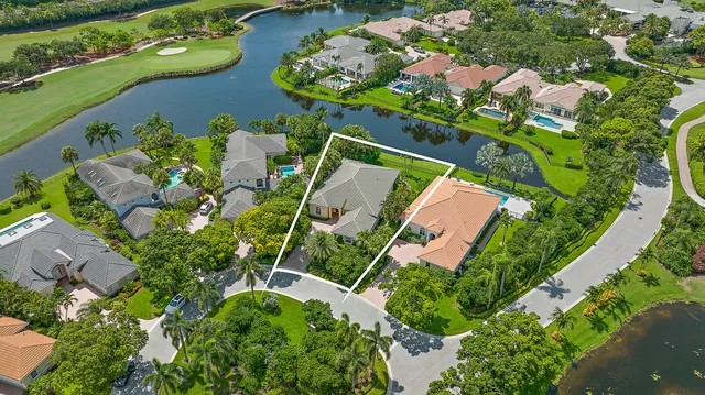 an aerial view of a house with a yard and lake view