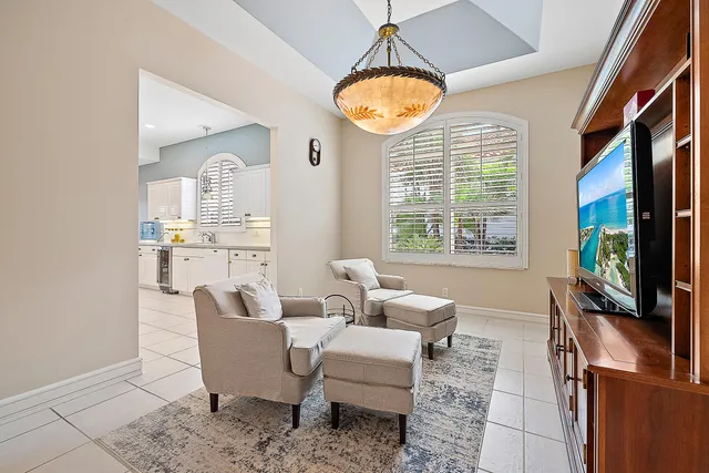 a living room with furniture a flat screen tv and a large window