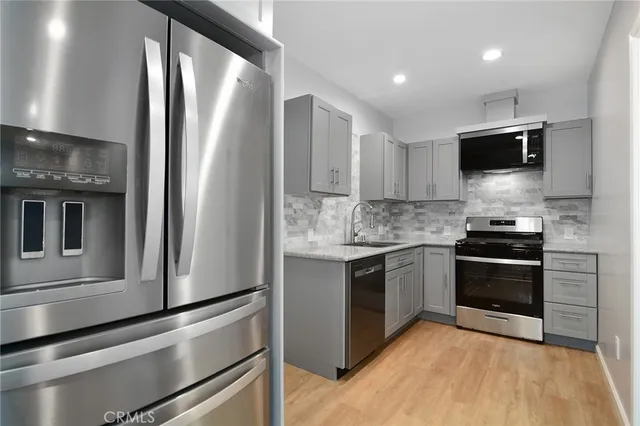 a kitchen with stainless steel appliances granite countertop a stove microwave and sink