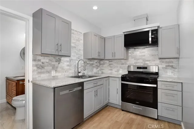 a view of a kitchen with a stove top oven and cabinets