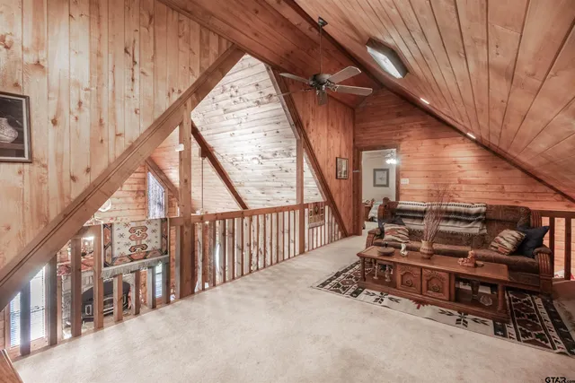 a view of an empty room with wooden floor and stairs