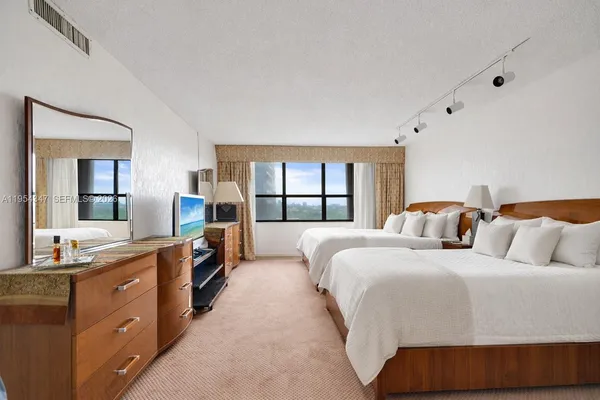 a bedroom with two beds and painting on the wall