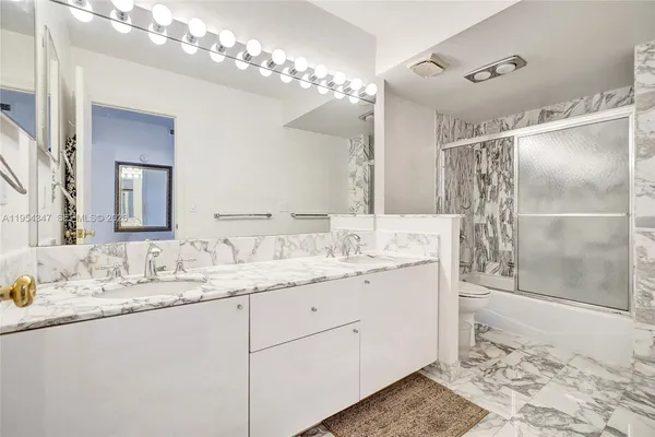 a bathroom with a granite countertop shower sink and vanity