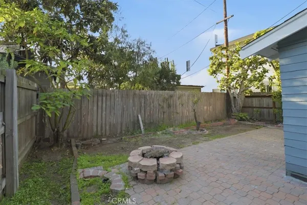 a backyard of a house with table and chairs potted plants