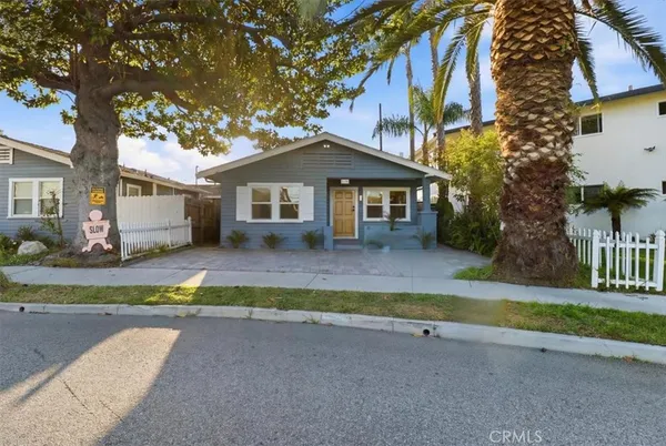 a view of a house with a yard and large tree