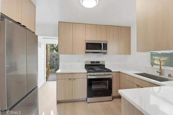 a kitchen with stainless steel appliances a stove a sink and a microwave