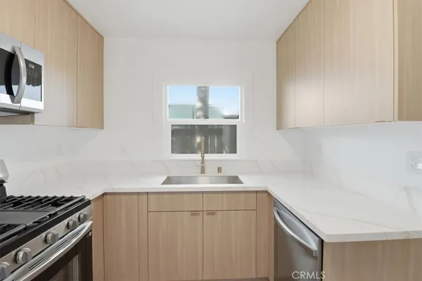 a kitchen with white cabinets sink and stove