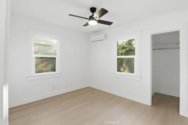 an empty room with windows and fan