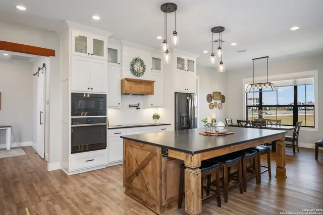 a kitchen with stainless steel appliances granite countertop a lot of counter space and wooden floors